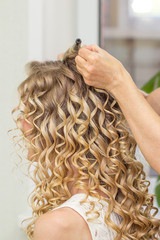 Naklejka premium Hair stylist makes the bride before wedding