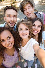 Happy friends taking selfie on street