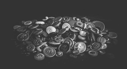 A bunch of old buttons on black velvet, Monochromatic vintage style.