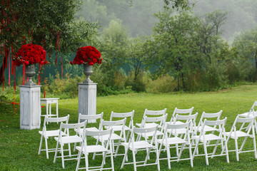 White chairs stand in rows before wedding altar