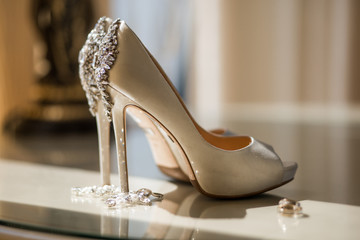 Beautiful shoes with crystals stand on table