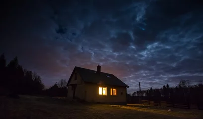 Selbstklebende Fototapete Nacht Landschaft mit Haus bei Nacht unter bewölktem Himmel