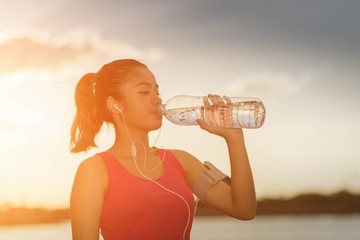 Beautiful fitness athlete woman drinking water after work out ex