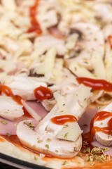 Sliced mushrooms on pizza with ham