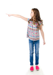 Cute little girl is pointing to the side isolated