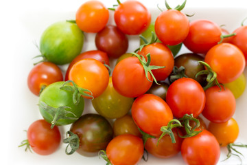 Various cherry tomatoes isolated on white background.