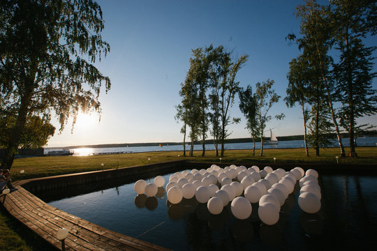 White balloons lie on the water in artificial lake