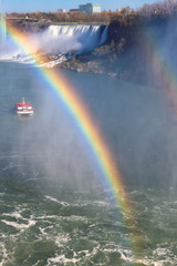 Spectacular rainbow near tourist boat at Niagara Falls