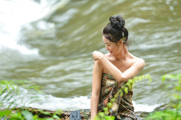 Asian woman wearing traditional thai take a baht on during sunset,vintage style,Beautiful woman take a baht,woman take a baht in river,Woman thai culture