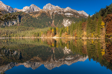 crystal clear mountain lake at sunset with light and sun filtering.Lake Tovel in Autumn. Italy