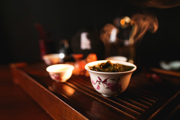 Traditional Chinese tea ceremony. Porcelain gaiwan with tea. Soft selective focus.