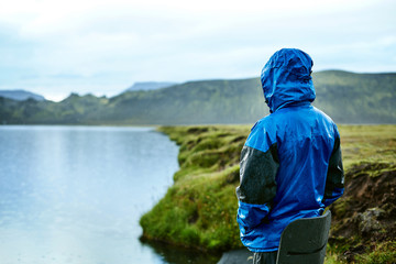 man on the Lake coast with mountain reflection at the rainy day, Iceland