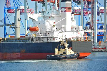 Tugboat assisting bulk cargo ship