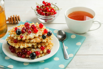 Baked waffles with fresh berries on the plate. Breakfast.