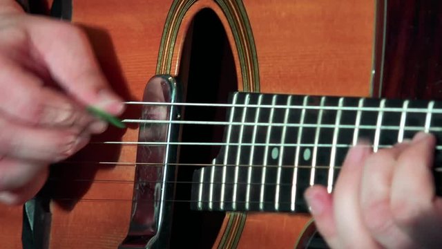 Man plays on guitar - close up hands and fingers on guitar