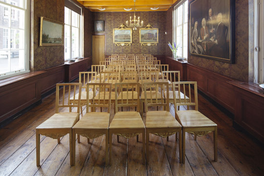 A room in a classical Dutch interior with many chairs used for ceremonies.