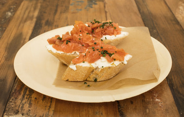 Salmon and cream cheese sandwiches on a wooden table