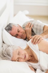 Fototapeta na wymiar Senior couple sleeping in bed