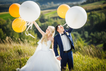 Wedding. Wedding day. Happy, smiling newlyweds with helium balloons having fun after wedding...
