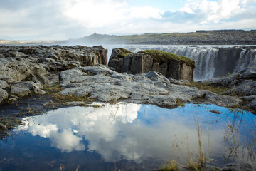 Сlouds reflection in a puddle. Sellfoss and Dettifoss waterfall