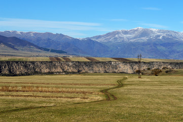 Obraz premium Rural road with mountains in the background