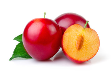 Red plum fruits with green leaves and slice isolated