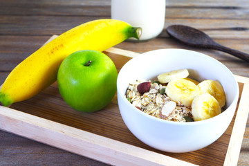 Close up of a bowl of muesli with banana, pumpkin seed, almond and fresh fruit.