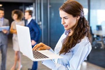 Fototapeta premium Confident businesswoman using laptop in office