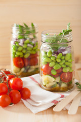 healthy vegetable salad in mason jar: tomato, cucumber, soybean,