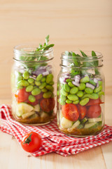 healthy vegetable salad in mason jar: tomato, cucumber, soybean,