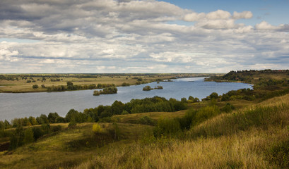 Typical russian landscape with river under cloudy sky