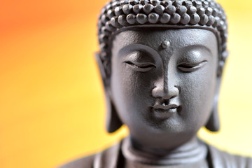 The face of Buddha Zen sculpture on a yellow background