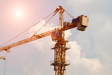 Crane and workers at construction site against blue sky