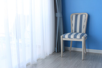 chair on wooden floor with curtain as background
