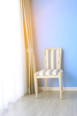 chair on wooden floor with curtain as background