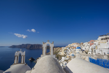 Scenic view of traditional cycladic white houses and blue domes in Oia village, Santorini island, Greece