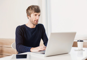 Portrait of a young business man working with laptop computer