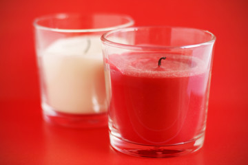 Vela roja y blanca apagadas sobre fondo rojo