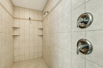 Long walk-in shower with two shower heads .