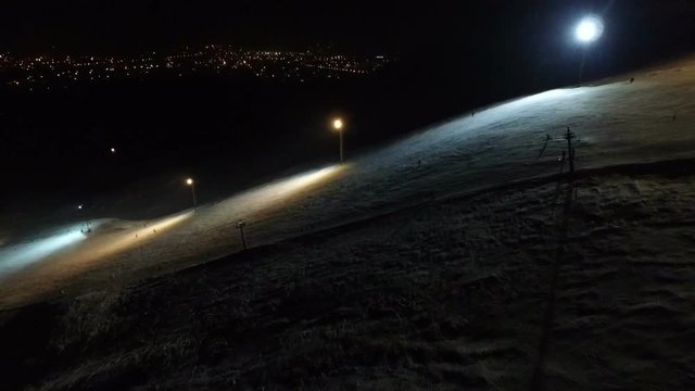 Ski resort slope on the night city background.