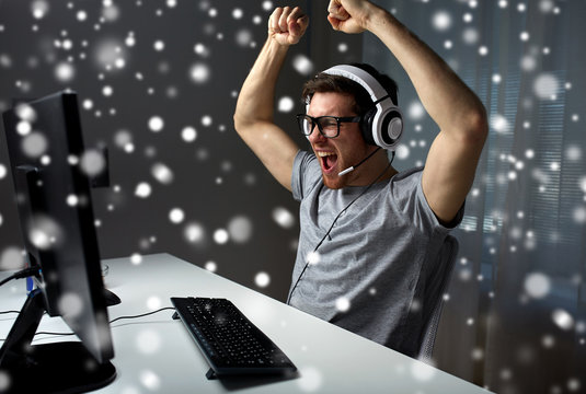 man in headset playing computer video game at home