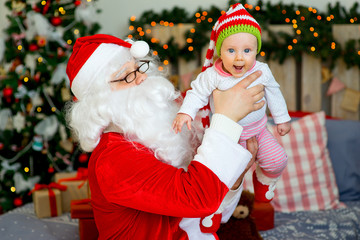 Fototapeta na wymiar little baby in the arms of Santa Claus