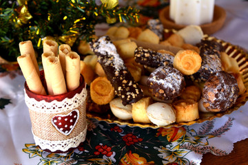 Christmas cookies on a plate and white lighted candle