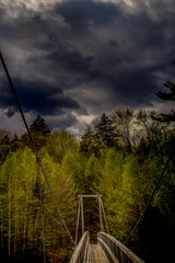 suspended bridge across stormy skies