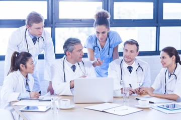 Fototapeta premium Medical team looking into laptop and having a discussion