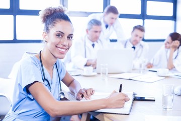 Portrait of female doctors writing on clipboard