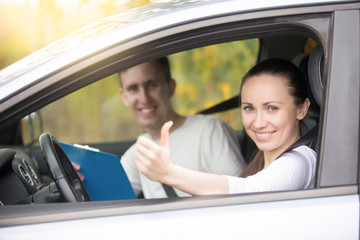 Lifestyle portrait of young happy confident lady have just finished drivers education class, showing thumb up, experienced casual instructor, holding a file folder is smiling too