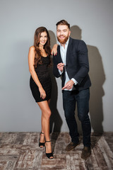 Cheerful young businesspeople in smart clothes dancing and having party