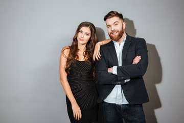 Couple in smart wear standing together and looking at camera