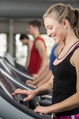 Obraz na płótnie Canvas Fit woman running on treadmill